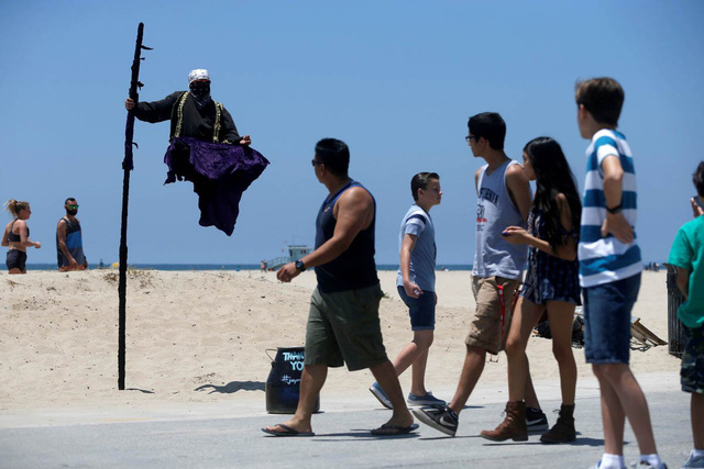 
Những người đi đường ngoái đầu xem một nghệ sỹ đường phố đang thể hiện màn biểu diễn kỳ lạ ở Los Angeles, California, Mỹ.
