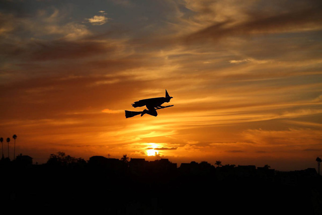 
Chiếc máy bay điều khiển từ xa mang mô hình một phù thủy cưỡi chổi bay ngang qua một khu phố khi ánh chiều tà đang buông xuống ở Encinitas, California.
