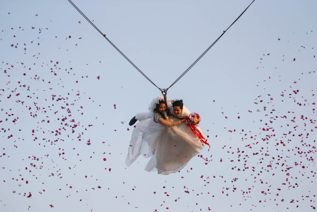 
Cặp đôi cô dâu chú rể cùng bay với sợi dây cáp trong ngày tổ chức lễ cưới đúng dịp Valentine thuộc khu nghỉ dưỡng ở tỉnh Ratchaburi, Thái Lan.

