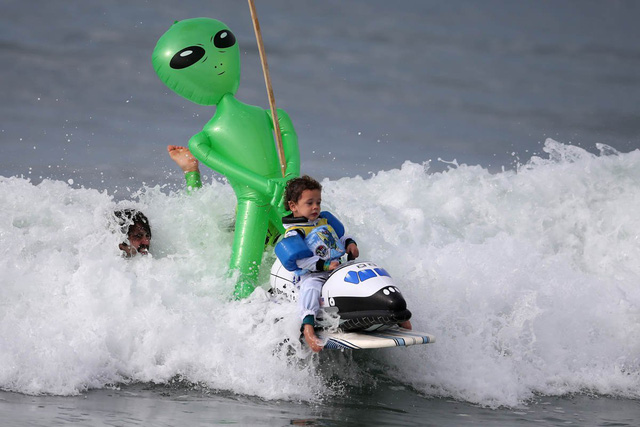 
Cậu bé 3 tuổi Oliver Quiros ăn mặc như một phi hành gia thực thụ, cưỡi tàu con thoi trong cuộc thi lướt sóng Halloween tổ chức tại Santa Monica, California.
