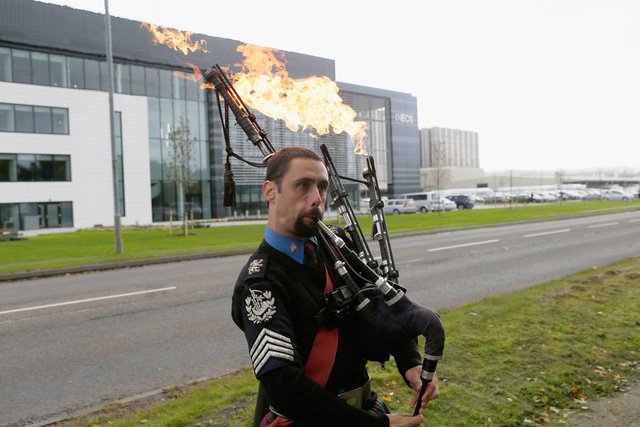 
Một nghệ sỹ đường phố có màn biểu diễn ấn tượng thổi kèn phun lửa bên ngoài trụ sở của Ineos ở Scotland, Anh.
