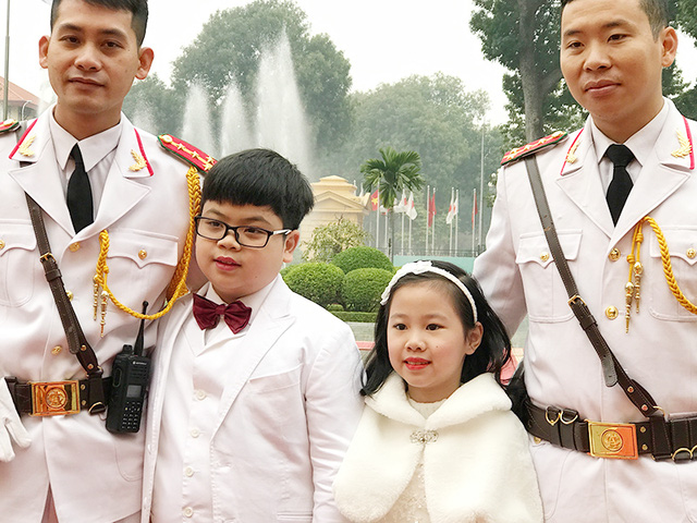 Nguyễn Như Khôi và bé gái cùng đón đoàn ngoại giao hoàng gia Nhật Bản, bên cạnh là các tiêu binh.
