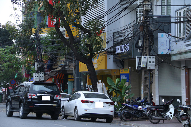 
Hai chiếc ô tô đỗ song song chiếm phân nửa lòng đường trên phố Hàng Bông.
