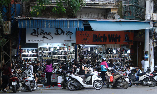 
Một của hàng kinh doanh giầy dép trên phố Hàng Buồm tấp nập khách ra vào mua hàng, xe máy đỗ tràn lan ra đường. Hình ảnh này diễn ra rất phổ biến tại nhiều tuyến phố trung tâm

