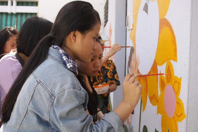 Học sinh thích thú tham gia vẽ tranh tường cùng thầy cô giáo.