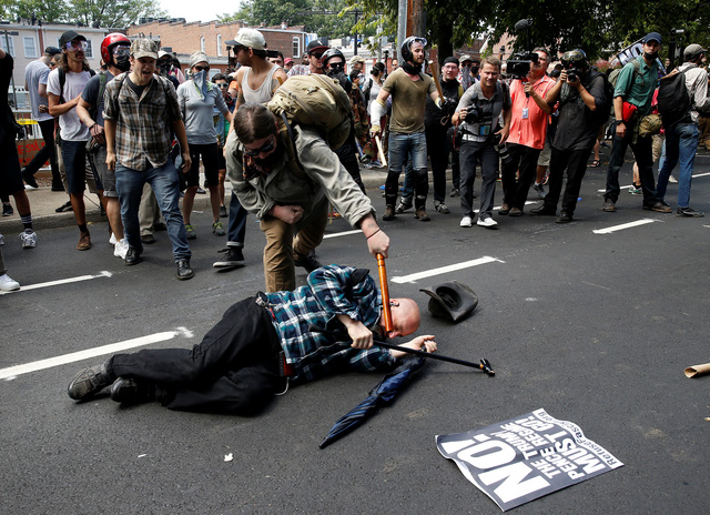 
Một người biểu tình phản đối cuộc tuần hành tấn công một người theo chủ nghĩa ủng hộ da trắng trên đường phố Charlottesville. (Ảnh: Reuters)
