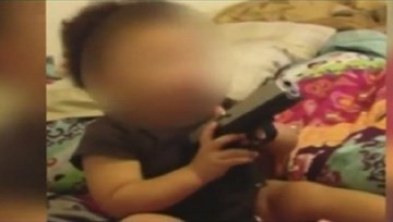 Cặp đôi người Mỹ bị bắt giữ vì để con ngậm súng