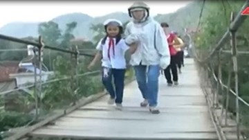 Học sinh run rẩy qua cầu treo đến trường