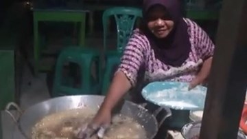 Người phụ nữ chiên bánh trong chảo dầu sôi bằng tay không