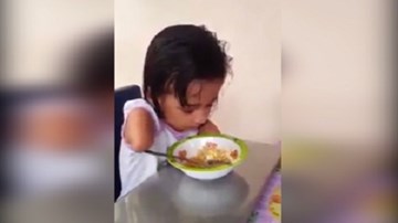 Bé gái cụt tay nhất quyết tự ăn cơm