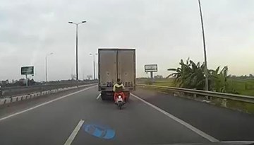 Thanh niên liều mạng núp sau xe tải để... tránh gió
