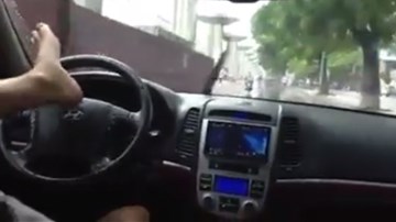 Trời mưa, lái ô tô bằng… chân