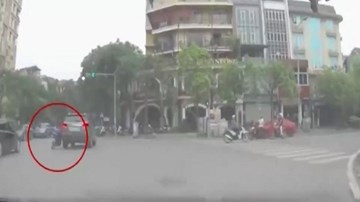 Bất chấp vượt đèn đỏ, xe máy đâm ô tô văng mạnh xuống đường