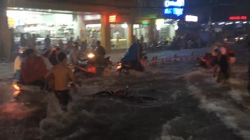 Nước chảy cuồn cuộn cuốn trôi xe máy ở ngay trên phố Sài Gòn
