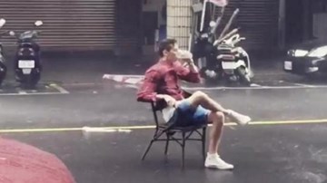 Thản nhiên đọc báo, uống trà trong siêu bão giữa đường phố