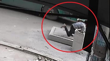 Người đàn ông mải đón xe buýt, bị rơi xuống hố ga