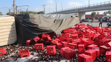 Xe tải chở bia lật vùi 2 người đi đường