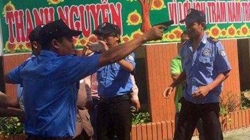 Nhóm bảo vệ chĩa súng, còng tay chủ trường giữa sân trường