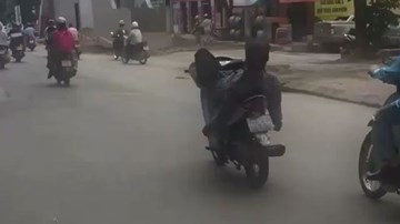 Thanh niên nằm ngửa, lái xe máy bằng chân như làm xiếc trên phố