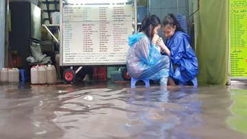 Người Sài Gòn vô tư ngồi uống trà sữa giữa biển nước sau mưa