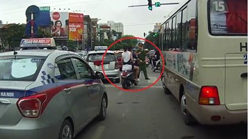Đôi nam nữ không đội mũ bảo hiểm vẫn luồn lách bị cảnh sát cầm dùi cui vụt