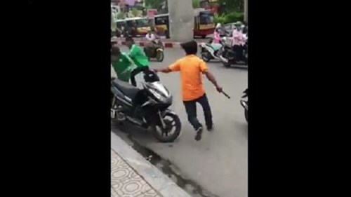 Tài xế xe ôm truyền thống cầm gậy truy đuổi lái xe GrabBike