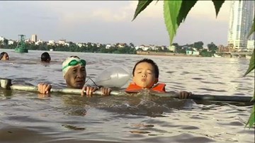 Cặp đôi ông cháu thích thú đi bơi khi nước sông Hồng lên cao