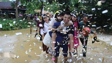 Chú rể quần xắn, chân đất cõng cô dâu vượt suối và đường lầy bùn