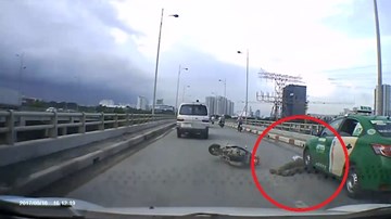 Xe máy ngã văng, thoát chết ngoạn mục trước đầu taxi ở TP.HCM
