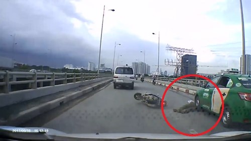 Xe máy ngã văng, thoát chết ngoạn mục trước đầu taxi ở TP.HCM