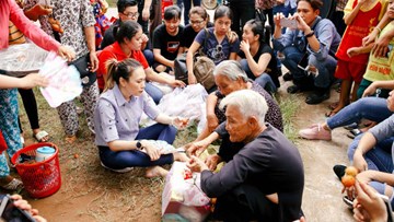 Mỹ Tâm ngồi bệt xuống đường, ăn chôm chôm với các cụ già neo đơn