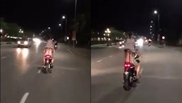 Bố lái xe máy chở con gái đứng trên yên phía sau vô tư nhún nhảy