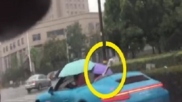 Bi hài cảnh 'dân chơi' lái siêu xe Porsche mui trần cầm ô che mưa