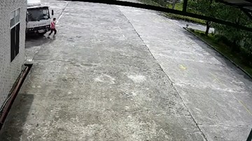 Đi bộ và không để ý, người phụ nữ bị xe tải cán, kéo lê trong sân