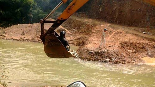 Cảnh người dân miền núi qua suối bằng máy múc