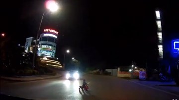 Người lớn bất cẩn để em bé ngồi xe lắc ra giữa đường tối, suýt bị xe tông