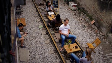 Khách Tây thích thú uống cà phê trên ray tàu hỏa ở Hà Nội