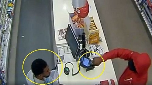 Bị nhân viên nhìn chằm chằm, tên cướp tẽn tò thu súng về, cầm kẹo bỏ đi