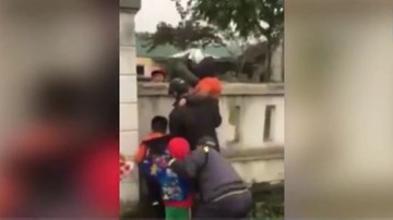 Phụ huynh trèo tường bế con vào lớp học