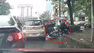 Taxi trả khách giữa ngã tư đèn đỏ, người đi xe máy ngã nhào vào vũng nước