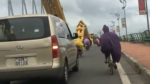 Ôtô đi chậm chắn gió giúp người phụ nữ đạp xe qua cầu ở Đà Nẵng