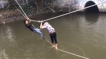 Hai thanh niên vắt vẻo bám dây thừng qua sông khiến dân mạng cười té ghế