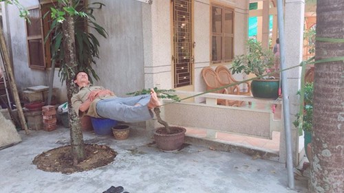 Người đàn ông thoải mái nằm ngủ trưa, đung đưa trên sợi dây dù