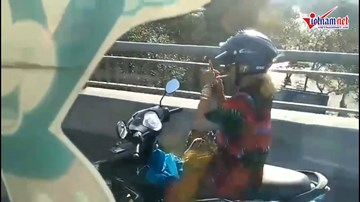 Nữ 'ninja' lái xe máy buông 2 tay, châm thuốc lá trên cầu
