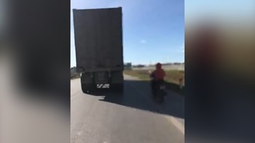 Hoảng hồn 'ninja' xe máy núp hông container để tránh nắng