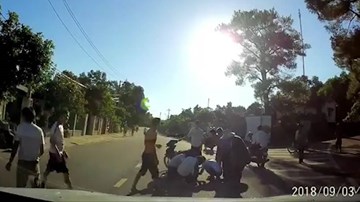 Mặc áo chống nắng quá dài, bé gái bị cuốn vào bánh xe máy của bố