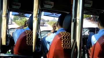Tài xế xe buýt vừa lái xe vừa gác chân nghe điện thoại