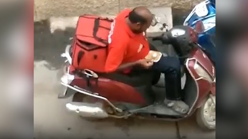 Anh shipper hồn nhiên ăn vụng thức ăn của khách hàng giữa đường