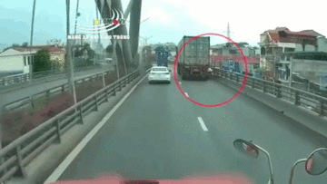 Đi vào đường cấm, xe máy thoát chết thần kỳ dưới bánh xe container