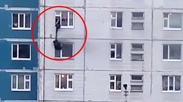 Người đàn ông lạ vươn mình ra ngoài cửa sổ cứu cô gái khỏi căn hộ đang cháy